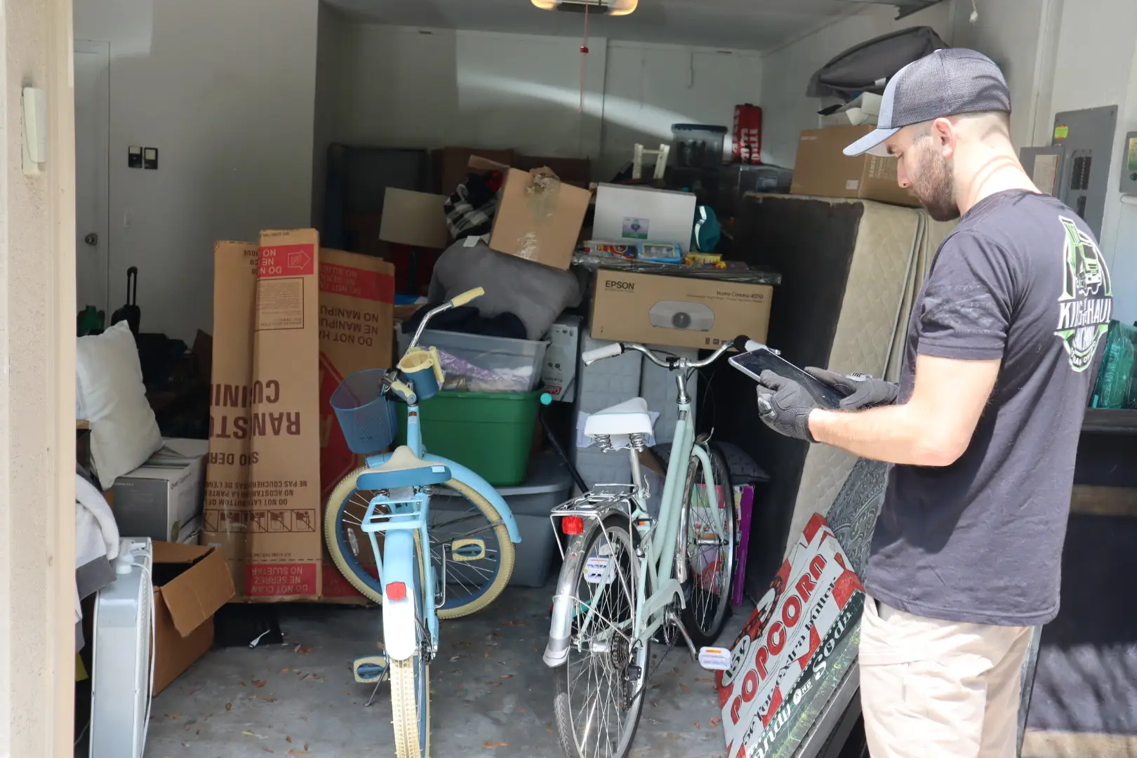 guy with ipad in front of garage full with stuff
